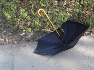 Der Regenschirm, weggeworfen an einer Stelle, an der Kinder täglich unter Polizeischutz auf ihren Schulbus warten.